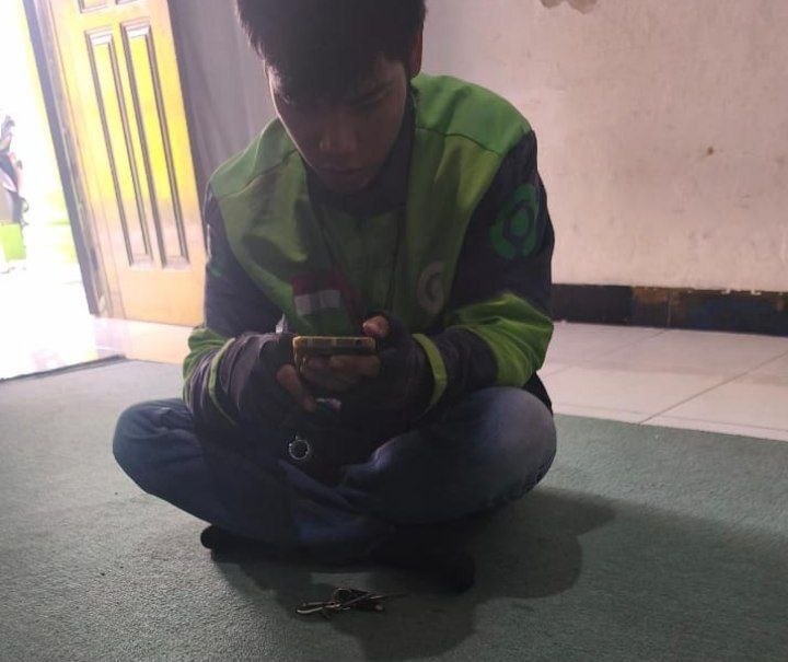 Bang Dikky Gea memegang foto lama ibunya, sebuah kisah pencarian ibu kandung yang mengharukan.